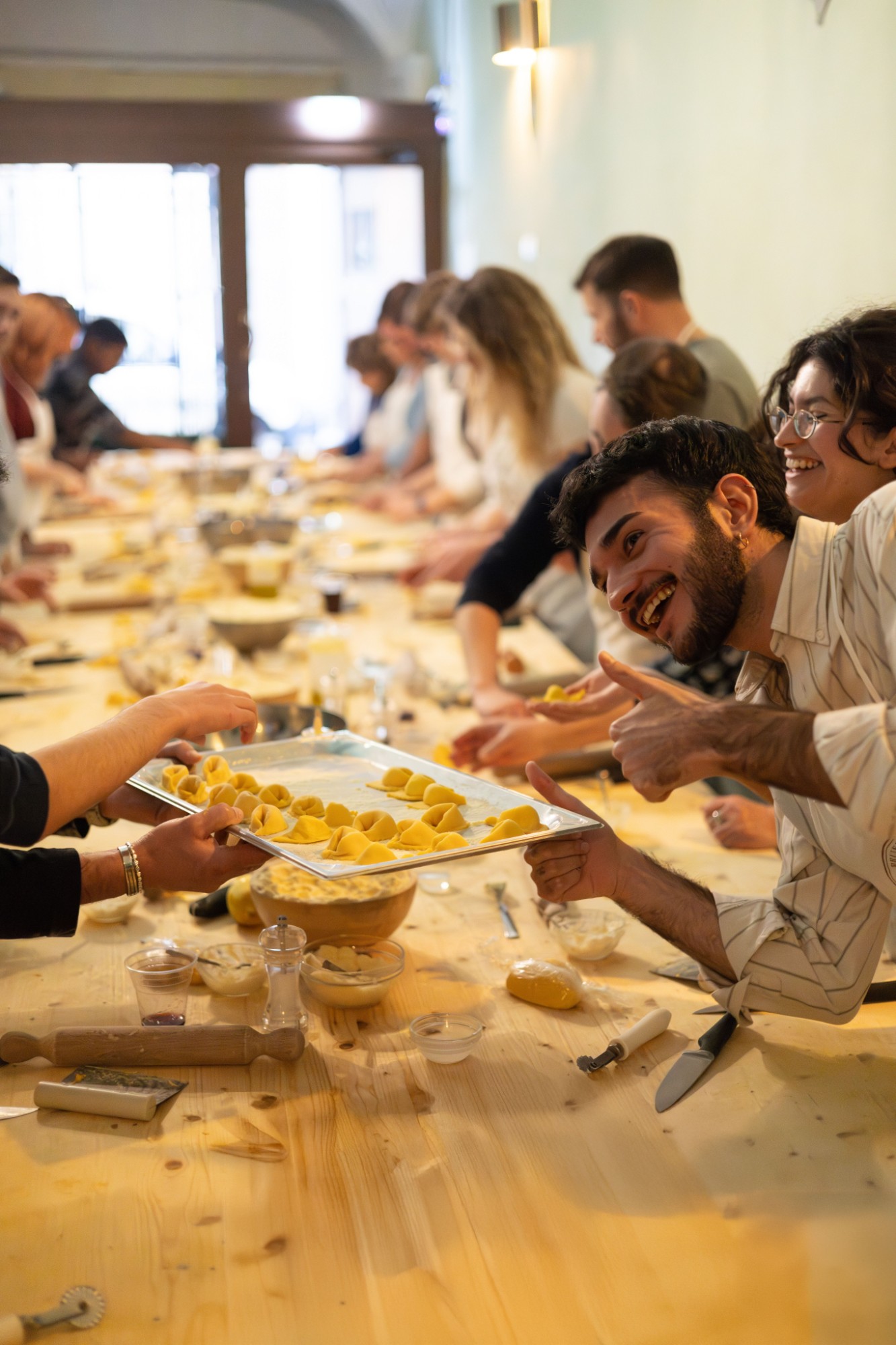 Smiling class participants with a tray of handmade tortellini